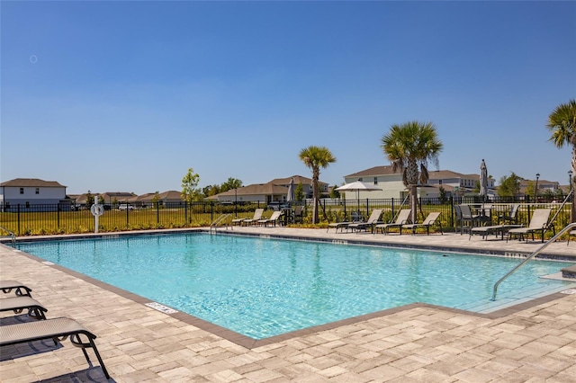pool featuring a patio area, a residential view, and fence