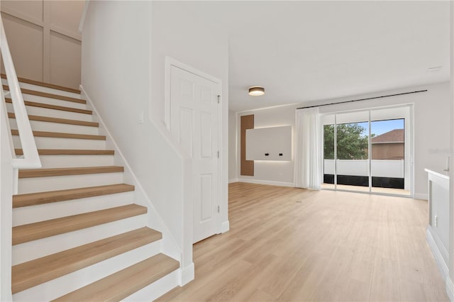 staircase featuring baseboards and wood finished floors