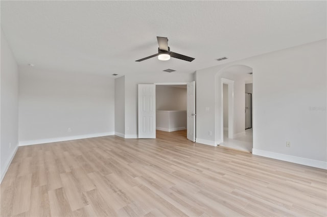 interior space featuring visible vents, light wood-style flooring, and arched walkways