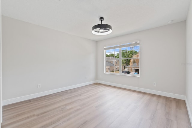 spare room with light wood-type flooring and baseboards