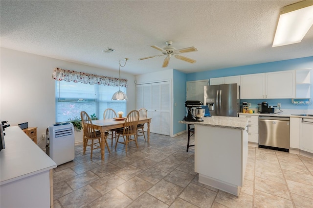 133 Wood Ibis Ct, Daytona Beach, FL 32119 - kitchen featuring white cabinetry, light countertops, a ceiling fan, and stainless steel appliances