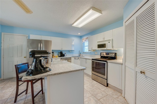 133 Wood Ibis Ct, Daytona Beach, FL 32119 - kitchen featuring light countertops, appliances with stainless steel finishes, a sink, and white cabinets