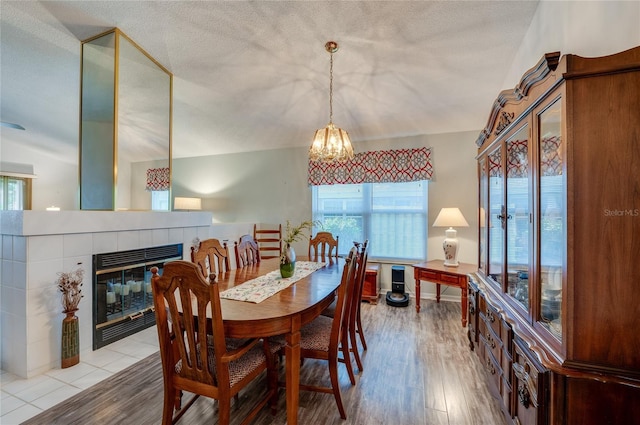 133 Wood Ibis Ct, Daytona Beach, FL 32119 - dining room with a chandelier, a fireplace, a textured ceiling, and wood finished floors