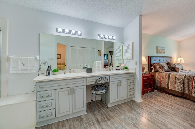 133 Wood Ibis Ct, Daytona Beach, FL 32119 - ensuite bathroom featuring a textured ceiling, wood finished floors, vanity, and connected bathroom