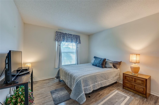 133 Wood Ibis Ct, Daytona Beach, FL 32119 - bedroom with a textured ceiling, baseboards, and wood finished floors