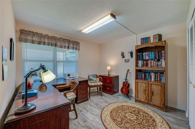 133 Wood Ibis Ct, Daytona Beach, FL 32119 - home office featuring baseboards, light wood-type flooring, and a textured ceiling