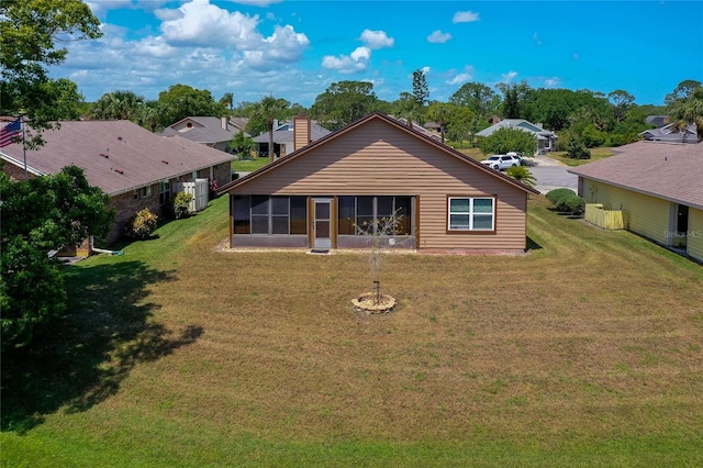 133 Wood Ibis Ct, Daytona Beach, FL 32119 - rear view of house with a sunroom, a chimney, and a lawn
