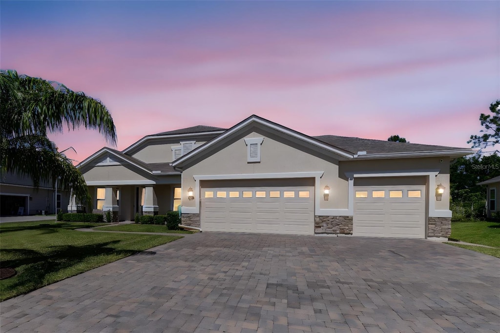 214 Ashford Lakes Cir, Ormond Beach, FL 32174 - craftsman-style house with stucco siding, an attached garage, a front lawn, and decorative driveway