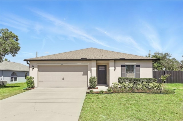 223 Courtland Blvd, Deltona, FL 32738 - view of front of home featuring a front yard, an attached garage, fence, stucco siding, and driveway