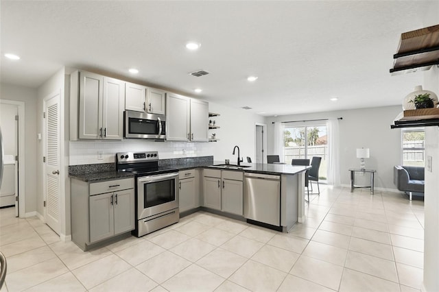 223 Courtland Blvd, Deltona, FL 32738 - kitchen featuring a peninsula, open shelves, visible vents, appliances with stainless steel finishes, and a sink