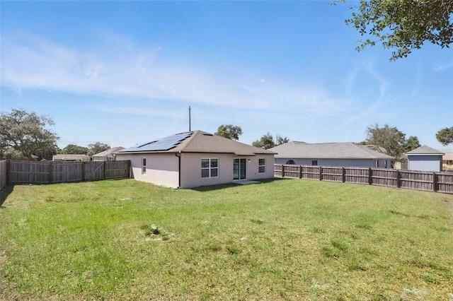 223 Courtland Blvd, Deltona, FL 32738 - rear view of house with a yard, a fenced backyard, solar panels, and stucco siding