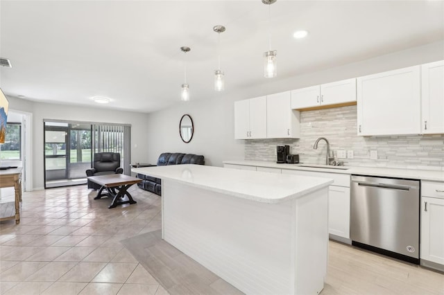 kitchen with open floor plan, white cabinetry, backsplash, dishwasher, and a sink
