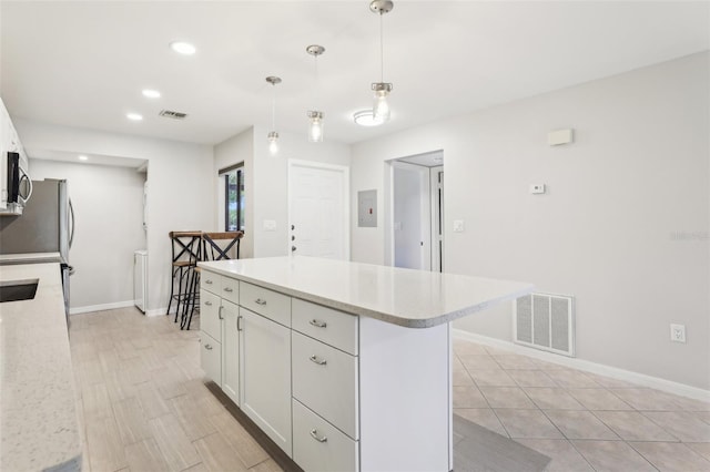 kitchen with visible vents, white cabinets, and baseboards