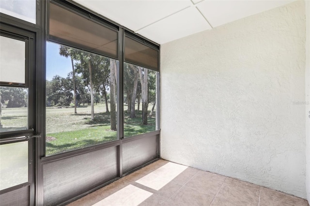 unfurnished sunroom featuring tile patterned flooring and a textured wall