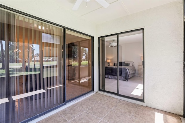 property entrance featuring ceiling fan and stucco siding