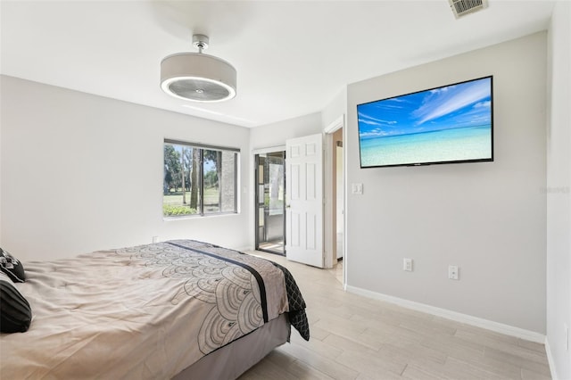 bedroom featuring light wood finished floors, baseboards, and visible vents