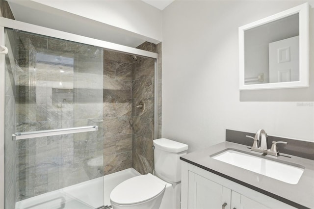 full bathroom featuring vanity, a stall shower, and toilet