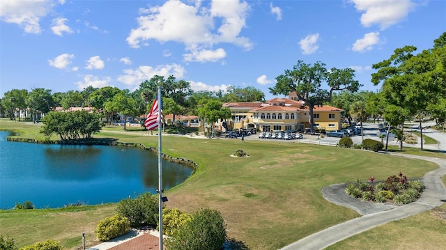 surrounding community with golf course view, a yard, and a water view