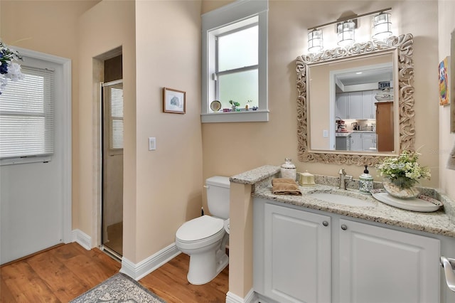 full bathroom with vanity, toilet, wood finished floors, and a stall shower
