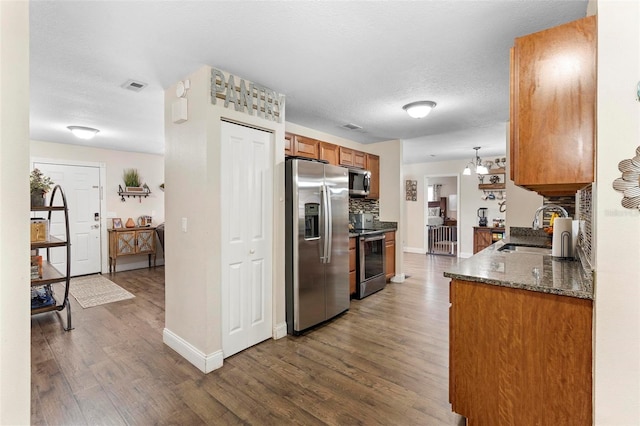 732 Mockingbird Ln, Deland, FL 32720 - kitchen featuring appliances with stainless steel finishes, a sink, brown cabinets, baseboards, and dark wood-style floors
