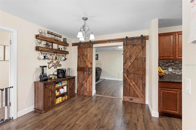 732 Mockingbird Ln, Deland, FL 32720 - dining room featuring dark wood-type flooring, a barn door, baseboards, and an inviting chandelier