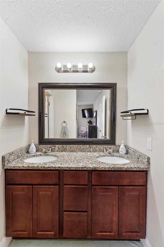 732 Mockingbird Ln, Deland, FL 32720 - bathroom featuring double vanity, a textured ceiling, and a sink