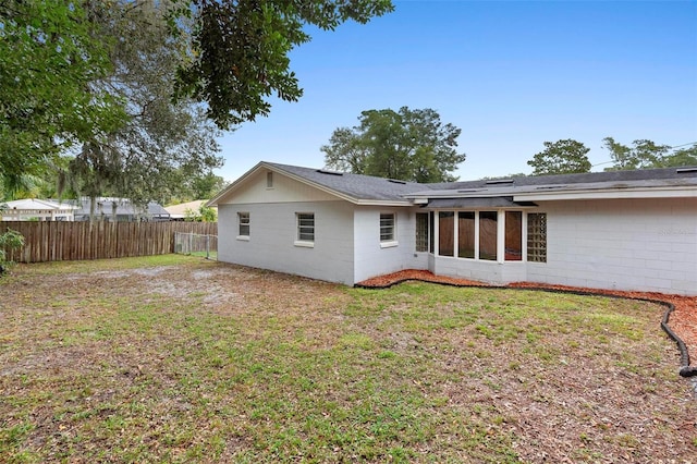 732 Mockingbird Ln, Deland, FL 32720 - back of house with a yard, a shingled roof, concrete block siding, and fence