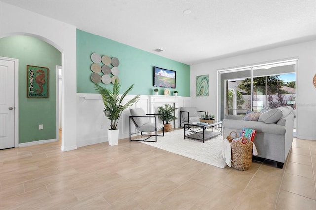 living room featuring arched walkways and visible vents