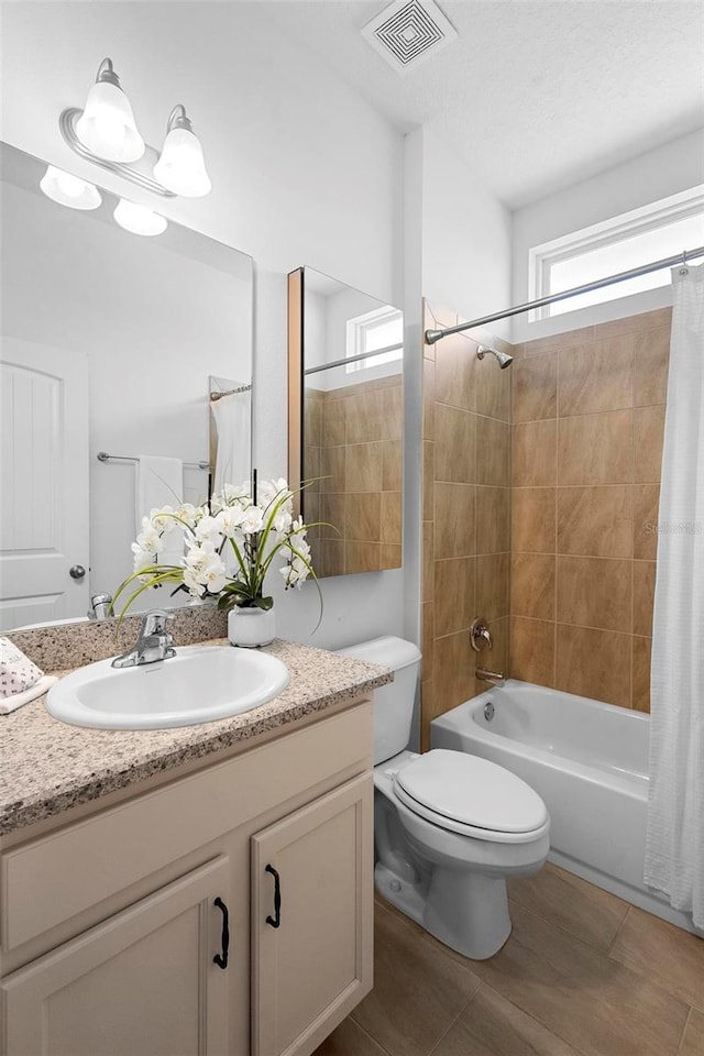 bathroom featuring shower / bath combo, toilet, vanity, and visible vents