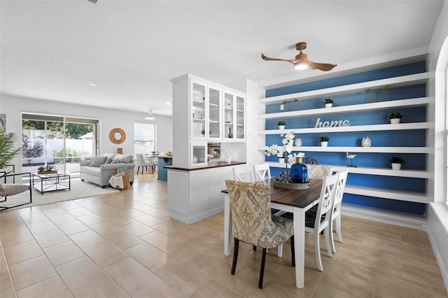 dining space with light tile patterned flooring, a ceiling fan, and built in shelves