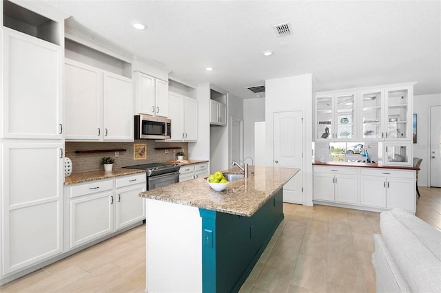 kitchen featuring white cabinets, decorative backsplash, visible vents, and appliances with stainless steel finishes