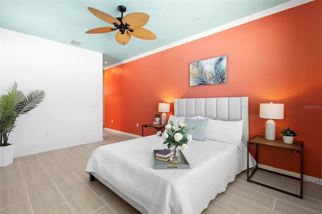 bedroom with a ceiling fan, baseboards, ornamental molding, and visible vents