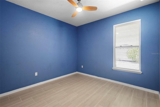 unfurnished room with baseboards and ceiling fan