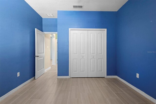 unfurnished bedroom featuring baseboards, visible vents, and a closet