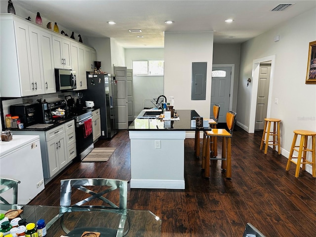 606 W Voorhis Ave, Deland, FL 32720 - kitchen with electric panel, stainless steel appliances, a sink, a center island with sink, and visible vents