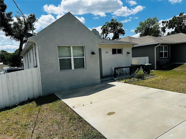 606 W Voorhis Ave, Deland, FL 32720 - view of front of home with stucco siding, a front lawn, fence, and a patio area