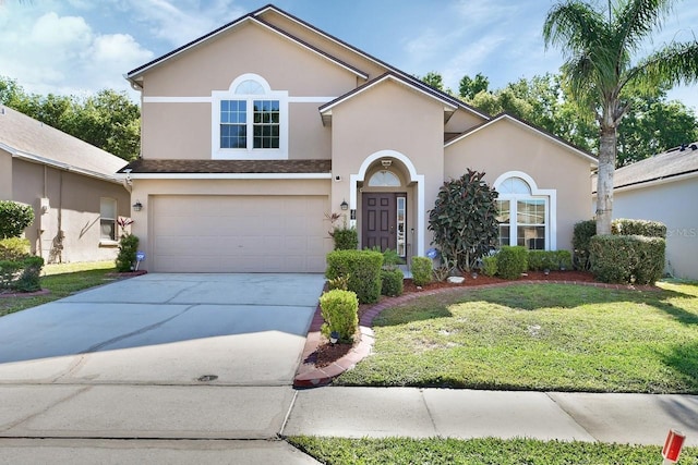 view of front of house with an attached garage, concrete driveway, a front yard, and stucco siding