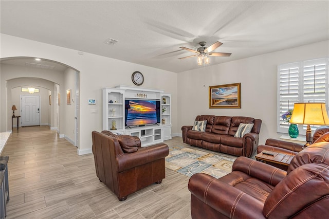 2901 Monaghan Dr, Ormond Beach, FL 32174 - living room with arched walkways, light wood-type flooring, baseboards, visible vents, and ceiling fan