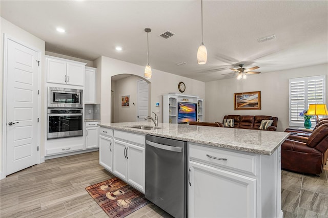 2901 Monaghan Dr, Ormond Beach, FL 32174 - kitchen with a sink, open floor plan, arched walkways, appliances with stainless steel finishes, and visible vents