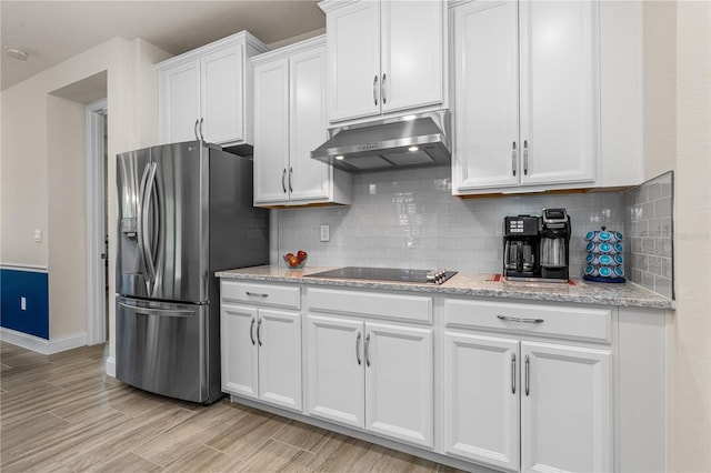 2901 Monaghan Dr, Ormond Beach, FL 32174 - kitchen featuring stainless steel fridge with ice dispenser, black electric cooktop, white cabinets, baseboards, and under cabinet range hood