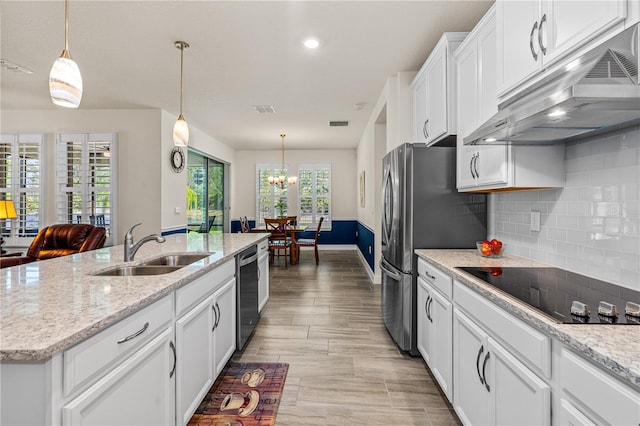 2901 Monaghan Dr, Ormond Beach, FL 32174 - kitchen featuring stainless steel appliances, a sink, a notable chandelier, backsplash, and under cabinet range hood