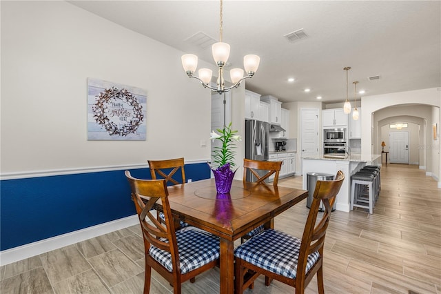2901 Monaghan Dr, Ormond Beach, FL 32174 - dining room featuring arched walkways, an inviting chandelier, baseboards, visible vents, and recessed lighting