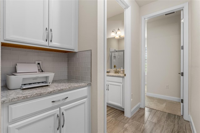 2901 Monaghan Dr, Ormond Beach, FL 32174 - interior space with visible vents, vanity, baseboards, decorative backsplash, and a stall shower
