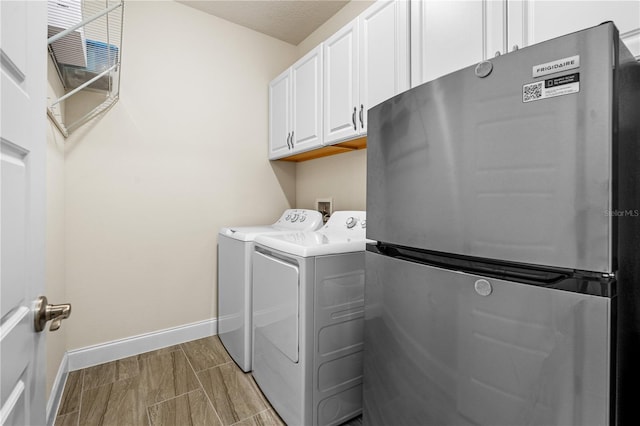 2901 Monaghan Dr, Ormond Beach, FL 32174 - clothes washing area featuring washing machine and clothes dryer, baseboards, and cabinet space