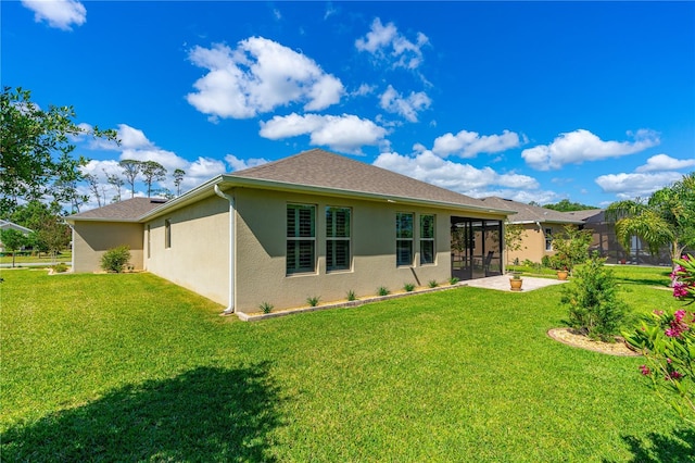 2901 Monaghan Dr, Ormond Beach, FL 32174 - rear view of property with a lawn, a shingled roof, a sunroom, and stucco siding