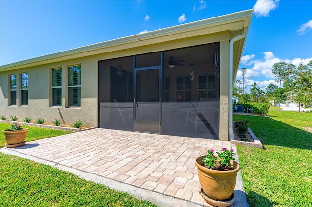 2901 Monaghan Dr, Ormond Beach, FL 32174 - back of house with driveway, a yard, a patio, stucco siding, and a sunroom