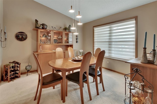 dining space with light carpet and baseboards