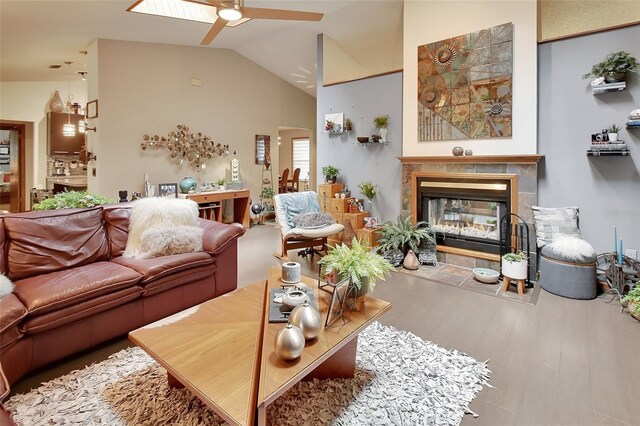 living room featuring a fireplace, lofted ceiling, wood finished floors, and a ceiling fan