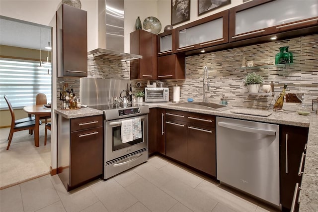 kitchen with stainless steel appliances, dark brown cabinetry, and wall chimney range hood