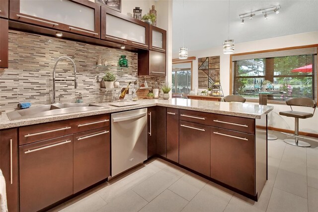 kitchen with a sink, decorative backsplash, glass insert cabinets, dishwasher, and a peninsula